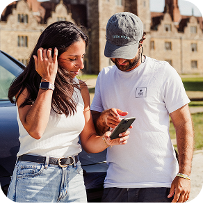 Couple sitting in back of a red car