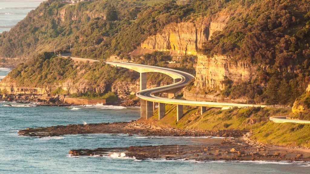 A wide shot of the Sea Cliff Bridge, a must do road trip route from Sydney as part of the Grand Pacific Drive.