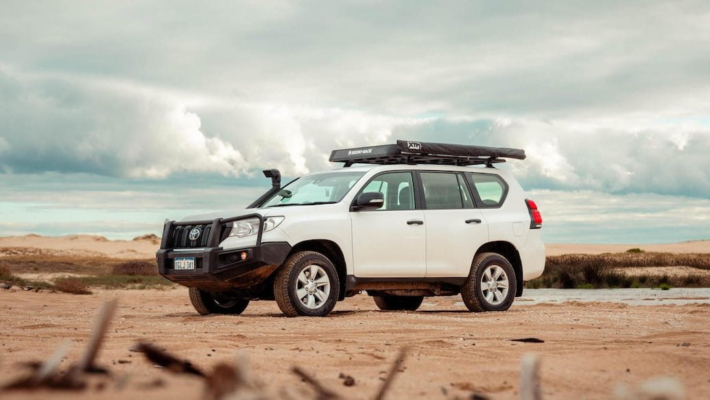 A white Toyota Landcruiser in the desert; the perfect car to get you to your next family holiday destination
