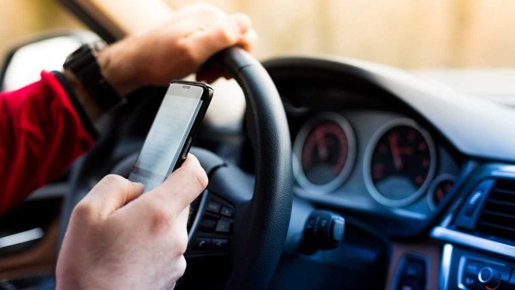 An overview of ACT (Australian Capital Territory) road rules. Photo shows a person texting and driving