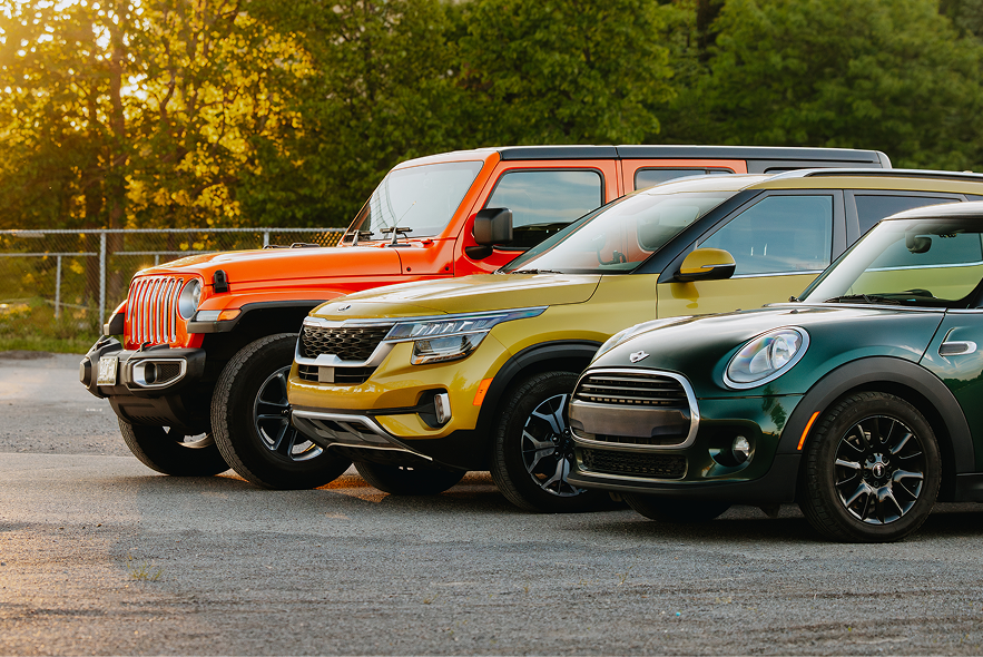 A trio of colourful vehicles are parked in a row.