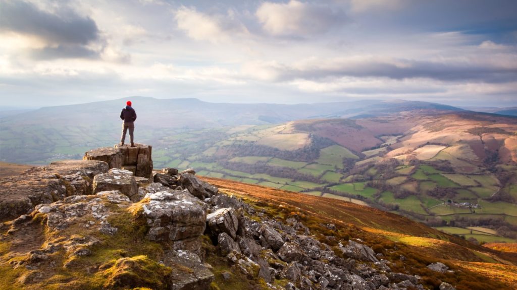 A man standing atop a mountain in the Brecon Beacons