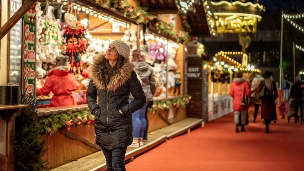 A woman browsing the Christmas market stalls in Edinburgh, Scotland, UK