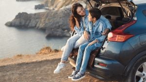 Mother and son sat by their car