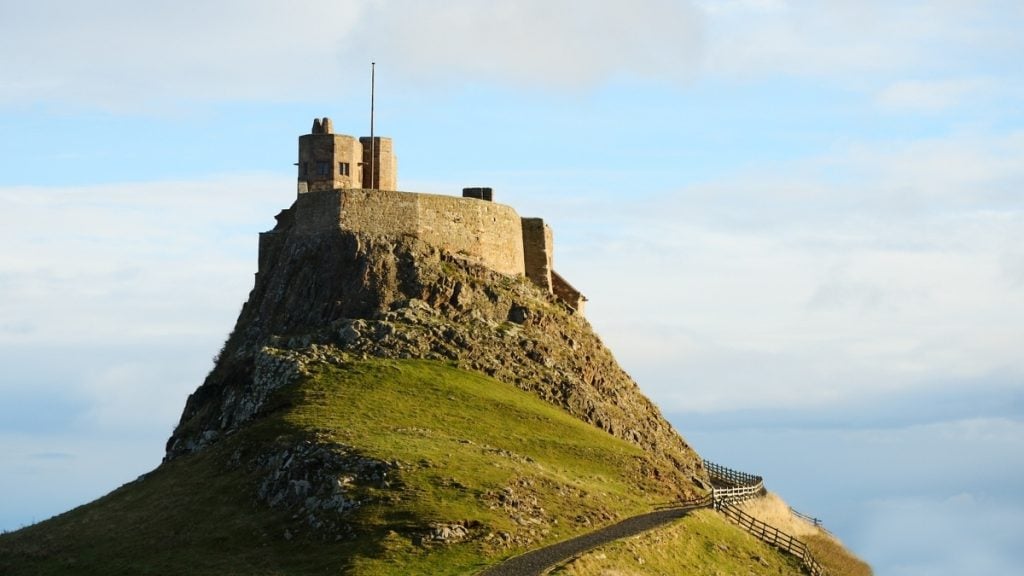 Lindisfarne Castle on a rocky hilltop overlooking the coast of Holy Island, Northumberland, England