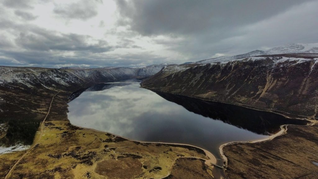 Loch Muick surrounded by steep hills and open landscape near the Snow Roads Scenic Route in the Cairngorms, Scottish Highlands, Scotland
