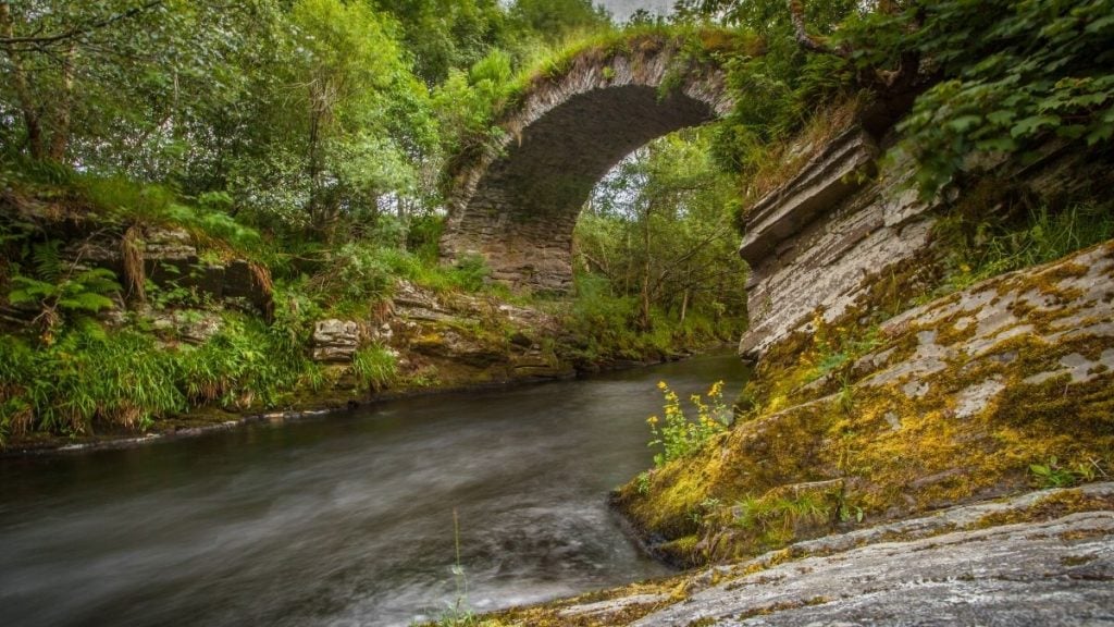 Historic stone Packhorse Bridge crossing a stream near Glenlivet in Ballindalloch, Cairngorms, Scottish Highlands, Scotland
