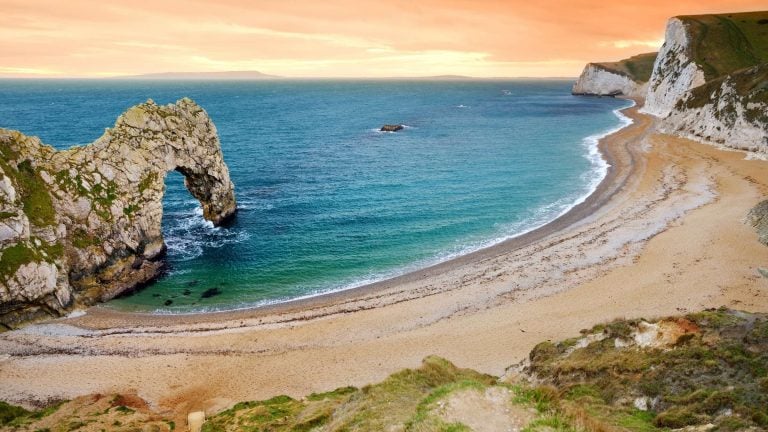 The ultimate Jurassic Coast road trip guide. In photo: Durdle Door bay on the Jurassic Coast in Dorset, UK
