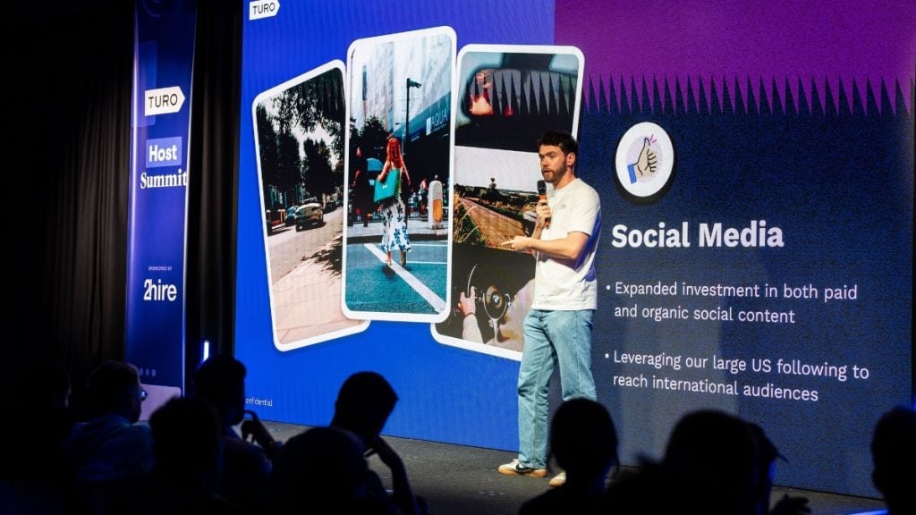 Liam White, Marketing Manager at Turo, presenting on stage during the UK Host Summit about how marketing, social media, and partnerships are helping attract more guests.