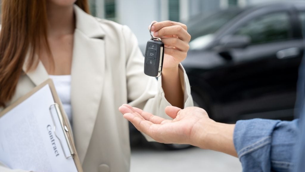 Leasing vs. buying a car vs. long-term rental: What’s the difference? In photo: Car keys being handed over during a lease agreement