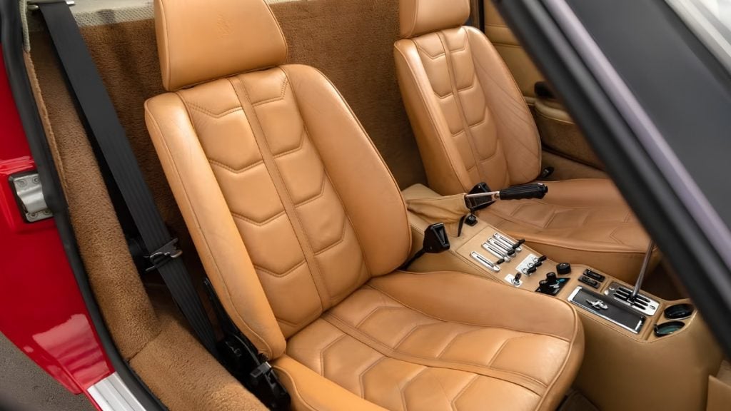 Tan leather two-seat cabin of a 1982 Ferrari 308 GTS showing the classic gated manual gearshift
