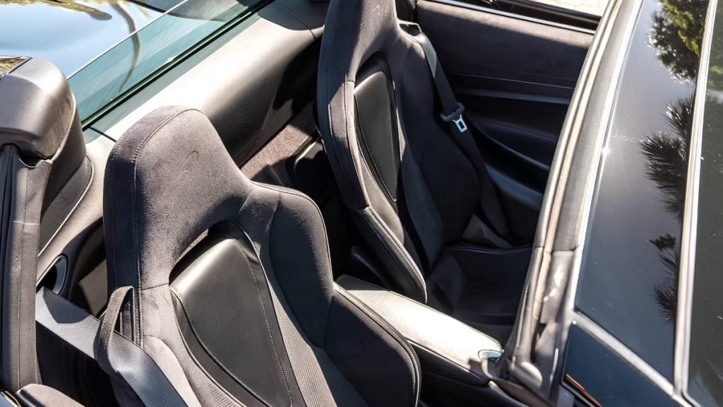 Close-up of the two-seat cabin in a McLaren 720S Spider with sculpted racing seats and glass-wrapped roof